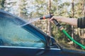 Hand with hose are spraying and cleaning a car Royalty Free Stock Photo