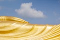 Hand of huge golden sleeping Buddha with blue sky