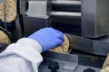 Hand of a human in glove works on conveyor. automatic line for the production of crispy whole grain bread at the factory