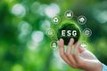 Hand of human holding green earth ESG icon for Environment Social and Governance.World sustainable environment concept on a green