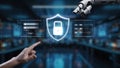 Hand of human and robotic arm interacting with digital shield symbolizing cybersecurity in a futuristic tech environment Royalty Free Stock Photo