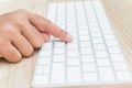Hand with injury on finger using white computer keyboard on wood Royalty Free Stock Photo