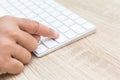 Hand with injury on finger using white computer keyboard on wood Royalty Free Stock Photo