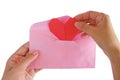 Hand inputting red heart paper origami into pink envelope Royalty Free Stock Photo