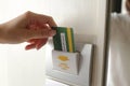 Hand insert room key card on hotel door