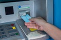 Hand inserting ATM credit card into bank machine Royalty Free Stock Photo