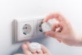 Hand Inserting Baby Safety Plugs Into Wall Socket To Prevent Danger At Home Royalty Free Stock Photo