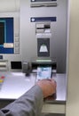 Hand inserting banknote into cash dispense Royalty Free Stock Photo