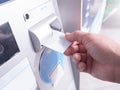 Hand inserting card into automatic teller machine