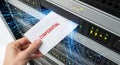 Hand inserting a confidential document into a server rack with glowing data streams Royalty Free Stock Photo