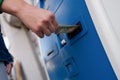 Hand inserting dollar money into bill acceptor closeup