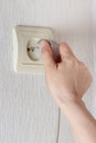 Hand inserting electric plug in the socket on the wall Royalty Free Stock Photo