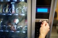 Hand inserting euro coin to vending machine slot