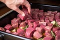 hand inserting garlic cloves in brisket for flavor development