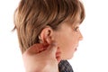 Hand inserting a hearing aid in a young boy`s ear Royalty Free Stock Photo
