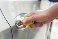 Hand inserting a key into the door of a car