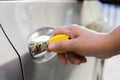 Hand inserting a key into the door of a car