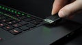 A hand inserting a USB drive into a laptop, suggesting data transfer or connectivity Royalty Free Stock Photo