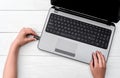 Hand inserting USB flash drive into laptop computer on white background. Close up of woman hand plugging pendrive on laptop.