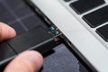 Hand inserting USB flash memory drive plugged into a computer laptop port. Royalty Free Stock Photo