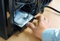 Hand inserts hard disk memory into system unit of computer Royalty Free Stock Photo