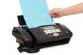 Hand inserts a paper into a fax