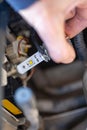 Hand installing H7 led headlight bulb with wires. Royalty Free Stock Photo