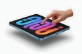 Hand interacting with a blue iPad Mini displaying colorful abstract graphics Royalty Free Stock Photo