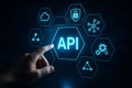 Hand interacting with a glowing api interface with surrounding technology icons Royalty Free Stock Photo