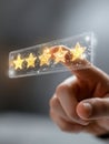 Hand interacting with glowing five-star rating icons in a futuristic digital interface representing customer satisfaction and Royalty Free Stock Photo
