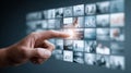 A hand interacts with a digital display of various images, highlighting the concept of choice and digital interface. Royalty Free Stock Photo