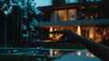 A hand interacts with a digital interface in front of a modern house, symbolizing smart property management Royalty Free Stock Photo