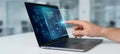 Hand interacting with holographic interface over laptop screen for futuristic digital workspace technology concept image Royalty Free Stock Photo