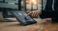A hand interacts with a tablet displaying various graphs and data visualizations,