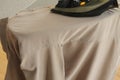 Hand ironing shirt on board with modern iron
