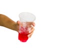 Hand isolated : A cropped female hand holding red sweet soda water in plastic glass giving on white background include clipping p Royalty Free Stock Photo