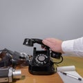 The hand of a journalist reaches for the phone. Old telephone set on a wooden table, retro installation. Copy space