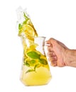 Hand with jug with spilling homemade lemonade