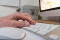 Hand on a keyboard with monitor and computermouse