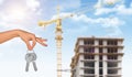 Hand with keys on construction site background Royalty Free Stock Photo