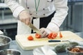 Hand with knife cuts tomato. Royalty Free Stock Photo