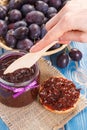 Hand with knife preparing fresh sandwiches with plum marmalade or jam, healthy sweet breakfast concept Royalty Free Stock Photo