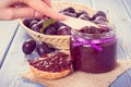 Hand with knife preparing fresh sandwiches with plum marmalade or jam, healthy sweet breakfast concept Royalty Free Stock Photo