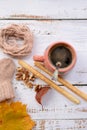 Hand-knitted brown baby socks, on white wooden background with autumn decorations Royalty Free Stock Photo