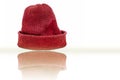 Hand knitted red-colored woolen cap isolated on white indicating Christmas. Royalty Free Stock Photo