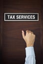 Hand is knocking on Tax services door Royalty Free Stock Photo