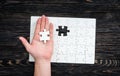 Hand with the last piece of white uncomleted puzzle Royalty Free Stock Photo