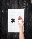 Hand with the last piece of white uncomleted puzzle Royalty Free Stock Photo