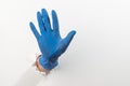 Hand in a latex glove showing an attention sign through torn white wall Royalty Free Stock Photo