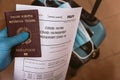 Hand with latex gloves holding covid vaccine passport concept with luggage at airport. traveling and tourism during covid19